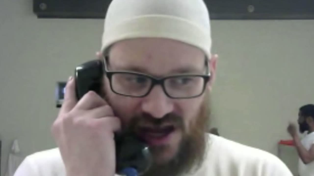 Adam Fox speaks on a telephone during a video call from inside federal prison